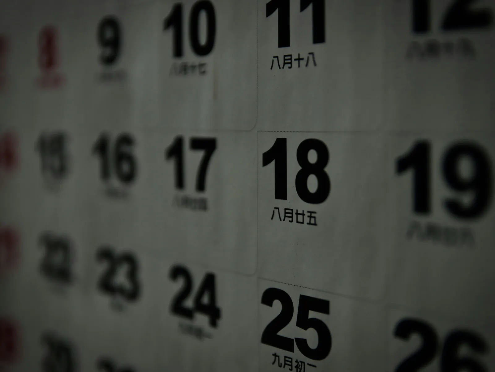 Calendário de parede em close com os dias numerados, representando os meses do ano em inglês