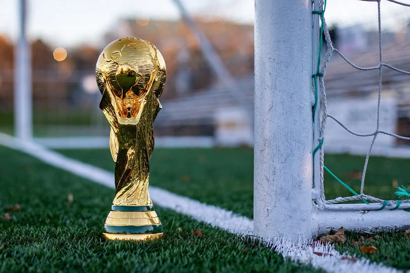 Taça de campeonato posicionada no centro do campo, representando conquistas no futebol profissional moderno